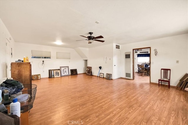 interior space with light wood-type flooring, baseboards, ceiling fan, and visible vents