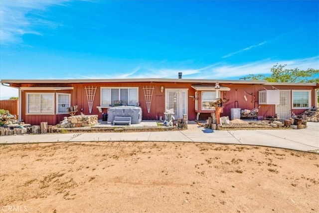 back of property with a hot tub