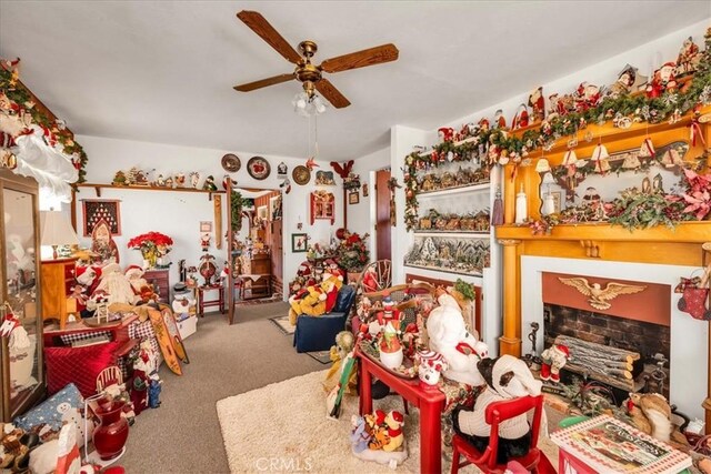 miscellaneous room featuring ceiling fan, a fireplace, and carpet flooring