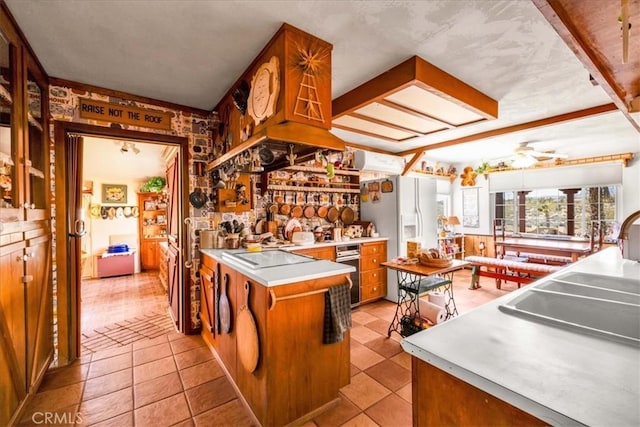kitchen featuring oven, white refrigerator with ice dispenser, a sink, electric cooktop, and brown cabinetry