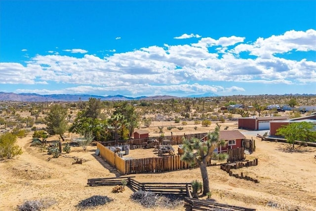 view of yard featuring a rural view, fence, a mountain view, and a desert view