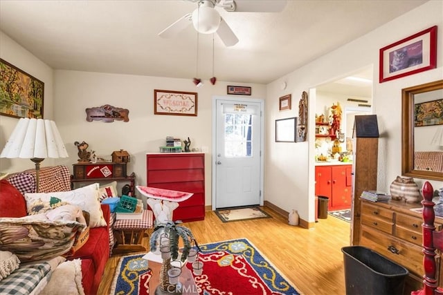 living room with baseboards, ceiling fan, and wood finished floors