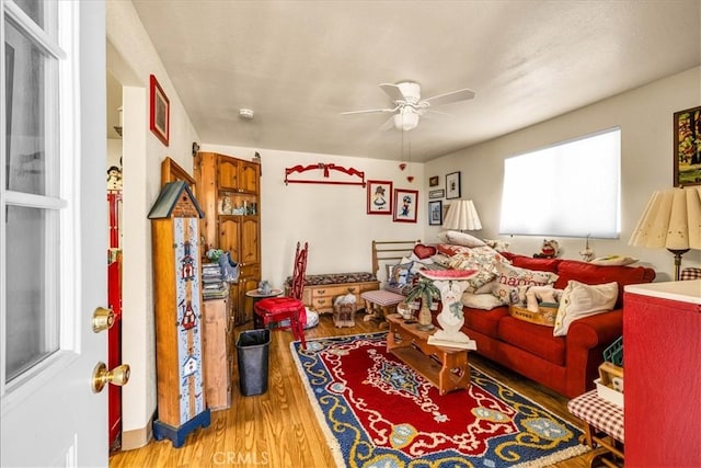 living area with ceiling fan and wood finished floors
