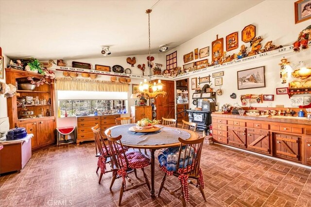 dining space with brick floor and lofted ceiling