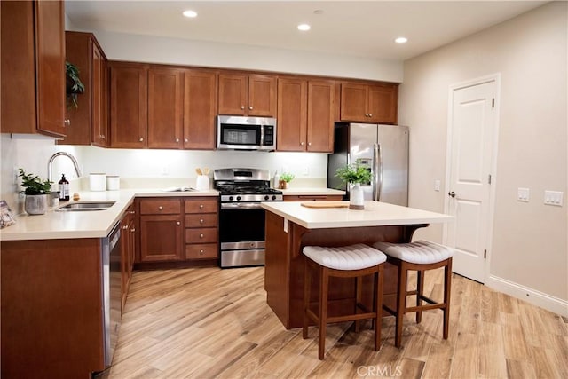 9369 Riberena Cir Unit 11, Atascadero, CA 93422 - kitchen with appliances with stainless steel finishes, light wood finished floors, a breakfast bar area, recessed lighting, and light countertops