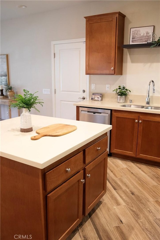9369 Riberena Cir Unit 11, Atascadero, CA 93422 - kitchen with light countertops, brown cabinetry, light wood-style floors, a kitchen island, and dishwasher
