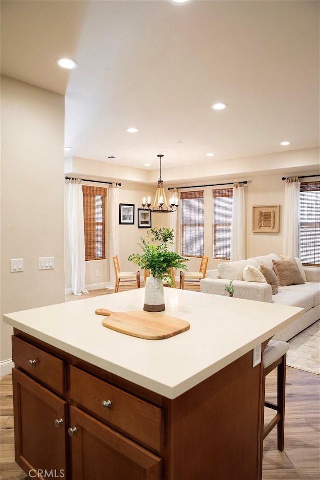 9369 Riberena Cir Unit 11, Atascadero, CA 93422 - kitchen with light wood-style flooring, a chandelier, a kitchen breakfast bar, decorative light fixtures, and light countertops