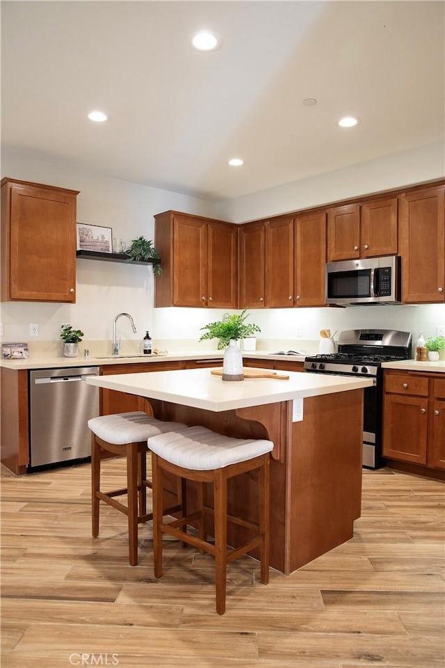 9369 Riberena Cir Unit 11, Atascadero, CA 93422 - kitchen with stainless steel appliances, light countertops, open shelves, a center island, and light wood-style flooring