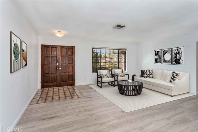 living area featuring visible vents, baseboards, and wood finished floors