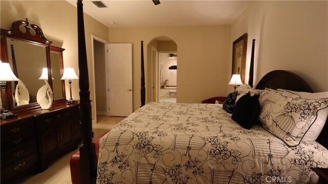 3615 Towhee Court, Punta Gorda, FL 33950 - bedroom with light wood-style flooring, connected bathroom, arched walkways, and visible vents