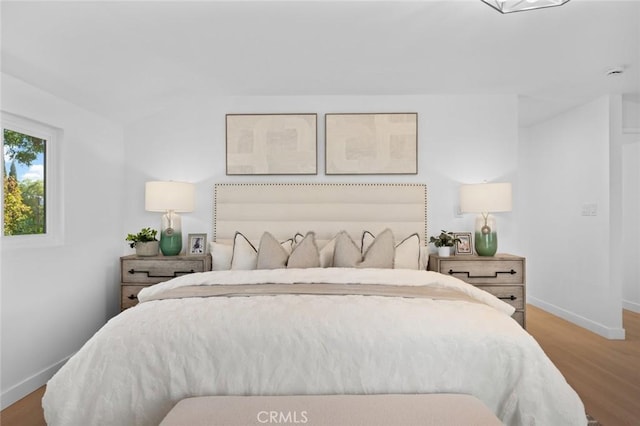 bedroom featuring baseboards and wood finished floors