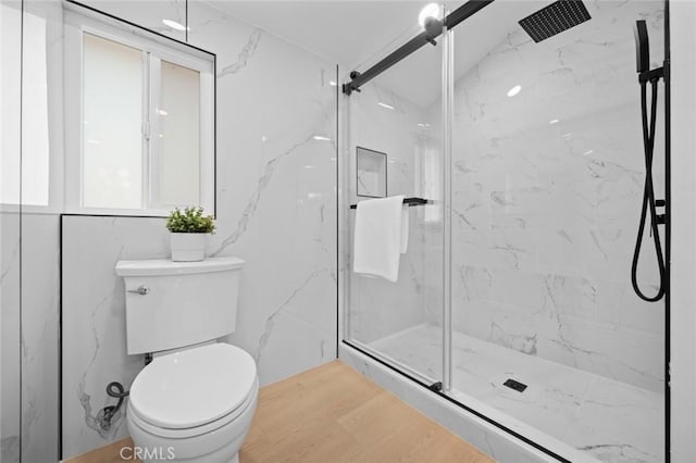 full bath with a marble finish shower and toilet