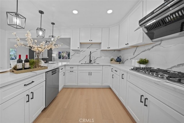 kitchen with a sink, ventilation hood, white cabinets, stainless steel appliances, and light wood-style flooring
