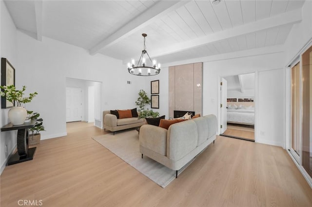 living area with baseboards, light wood-style flooring, beam ceiling, and a notable chandelier