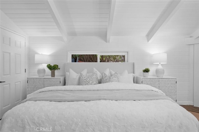 bedroom featuring beam ceiling and wood finished floors