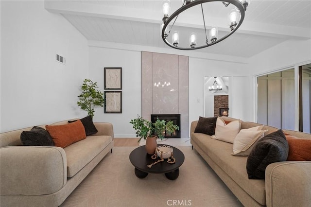 living room featuring a stone fireplace, visible vents, beam ceiling, a chandelier, and light wood-style flooring