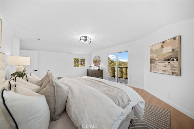 bedroom with access to outside, baseboards, and wood finished floors
