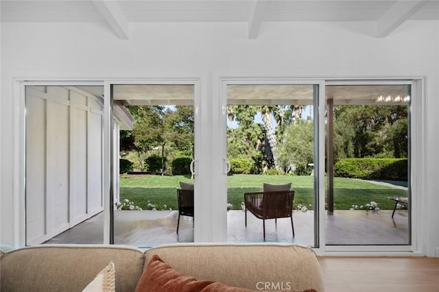 doorway to outside with wood finished floors and beamed ceiling