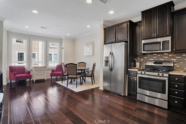 kitchen with light countertops, ornamental molding, stainless steel appliances, baseboards, and dark wood-style floors