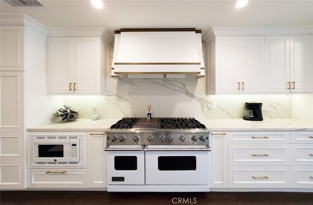 16143 Saint Croix Cir, Huntington Beach, CA 92649 - kitchen featuring range with two ovens, range hood, white microwave, white cabinets, and decorative backsplash