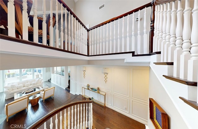 16143 Saint Croix Cir, Huntington Beach, CA 92649 - stairs featuring hardwood / wood-style floors, a decorative wall, and a towering ceiling