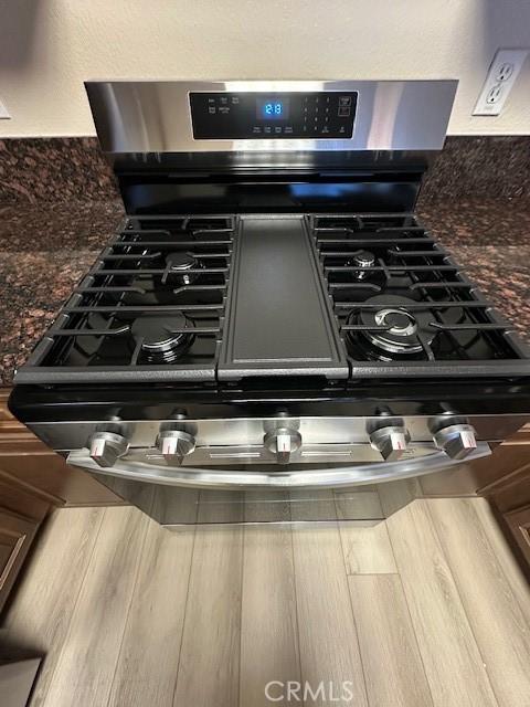 details featuring dark countertops and stainless steel gas range oven