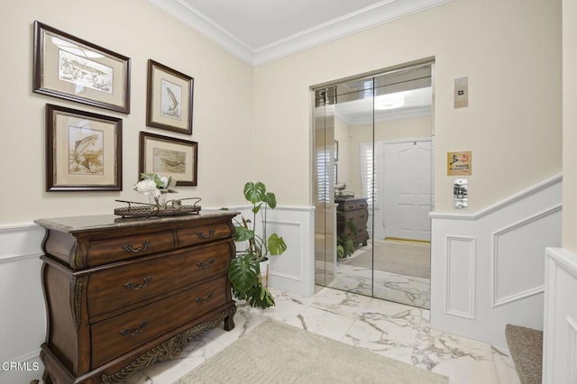 bathroom featuring a decorative wall, marble finish floor, vanity, ornamental molding, and wainscoting