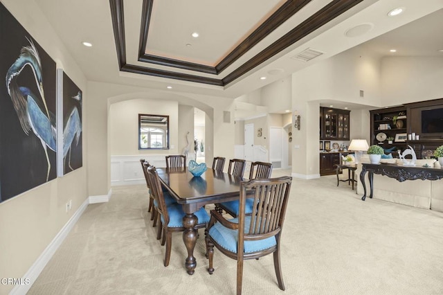 dining room with arched walkways, ornamental molding, recessed lighting, and light colored carpet
