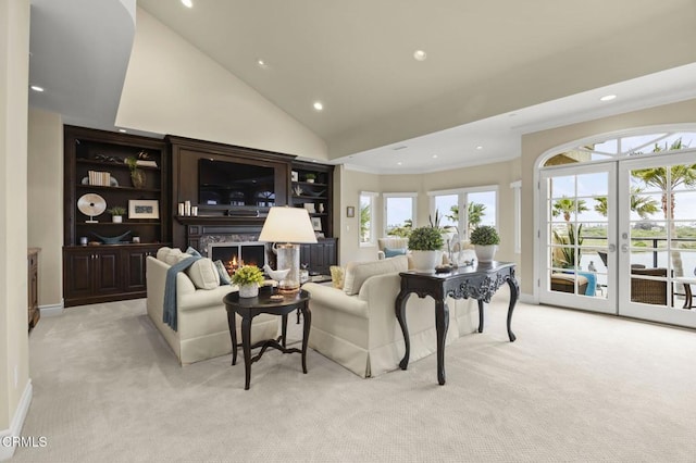 living area featuring vaulted ceiling, light carpet, a warm lit fireplace, and recessed lighting