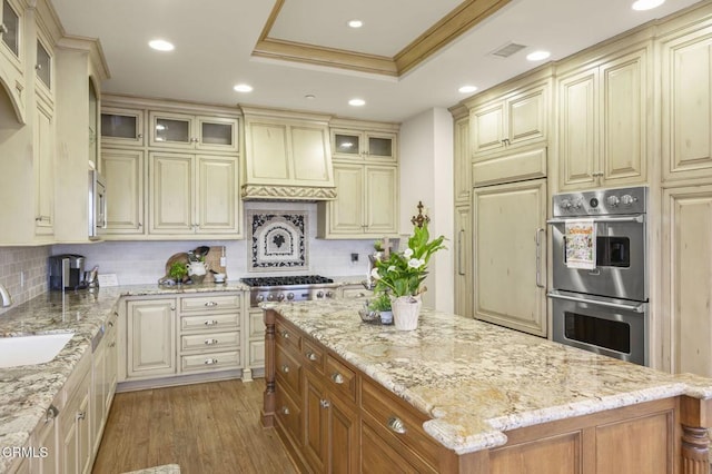 kitchen with cream cabinets, decorative backsplash, and appliances with stainless steel finishes