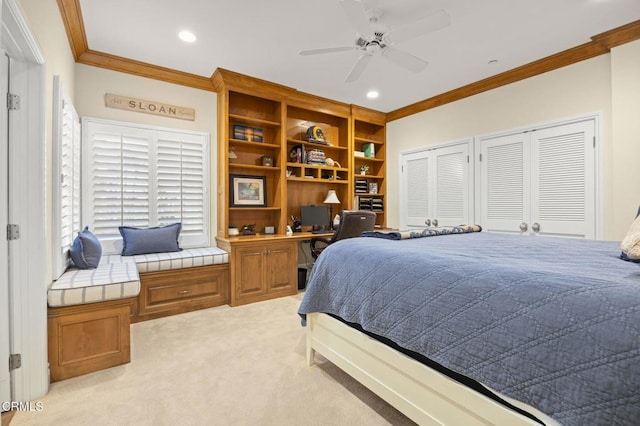 bedroom featuring built in study area, crown molding, light carpet, and two closets