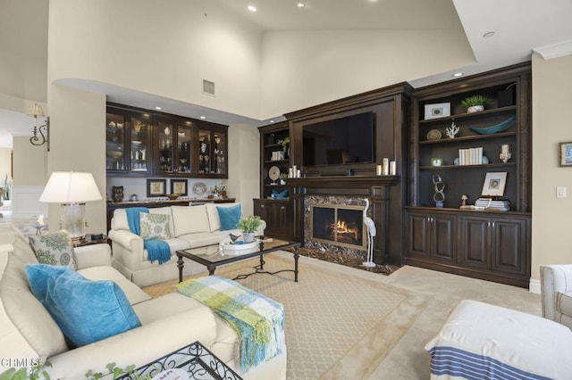living room featuring high vaulted ceiling, visible vents, a high end fireplace, and recessed lighting