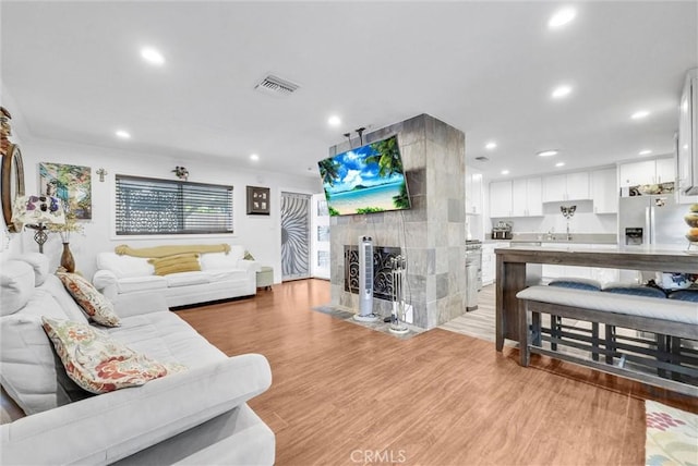 24 S La Salle St, Redlands, CA 92374 - living room with recessed lighting, light wood-type flooring, visible vents, and a tile fireplace
