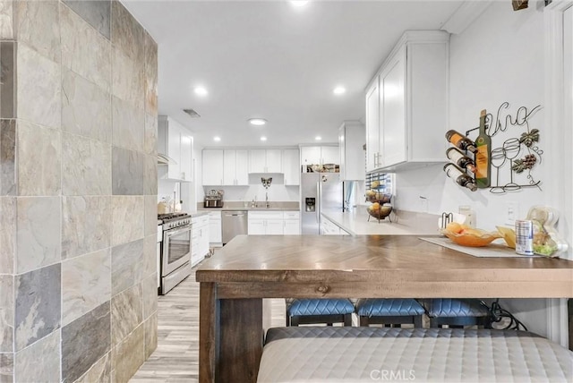 24 S La Salle St, Redlands, CA 92374 - kitchen featuring stainless steel appliances, recessed lighting, white cabinetry, and visible vents