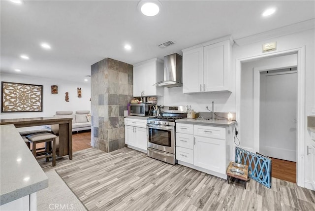 24 S La Salle St, Redlands, CA 92374 - kitchen with recessed lighting, appliances with stainless steel finishes, light wood finished floors, and wall chimney exhaust hood