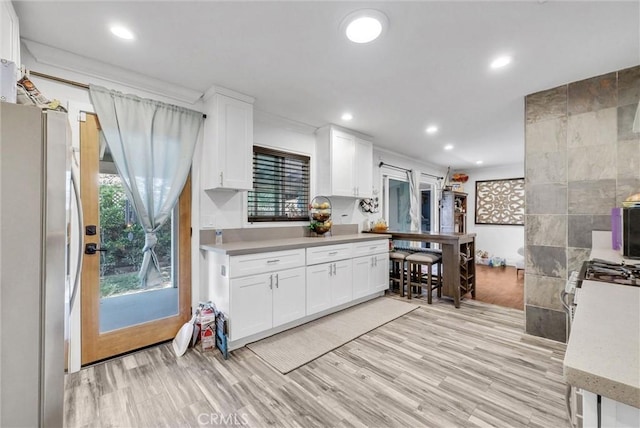 24 S La Salle St, Redlands, CA 92374 - kitchen with recessed lighting, freestanding refrigerator, white cabinetry, and light countertops