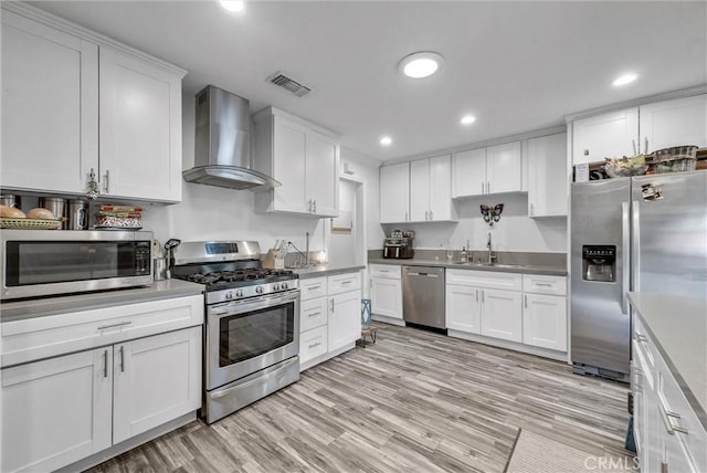 24 S La Salle St, Redlands, CA 92374 - kitchen with wall chimney range hood, visible vents, appliances with stainless steel finishes, a sink, and white cabinetry