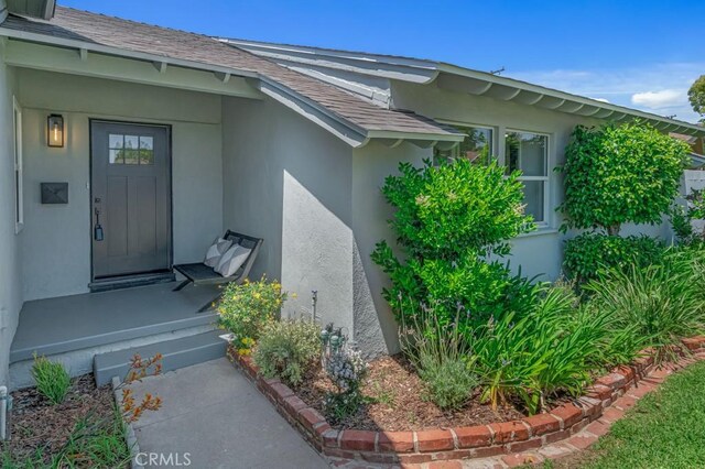 413 N Rimhurst Ave, Covina, CA 91724 - view of exterior entry featuring a shingled roof and stucco siding