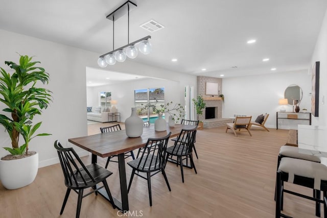413 N Rimhurst Ave, Covina, CA 91724 - dining space featuring a fireplace, light wood-style floors, recessed lighting, baseboards, and visible vents