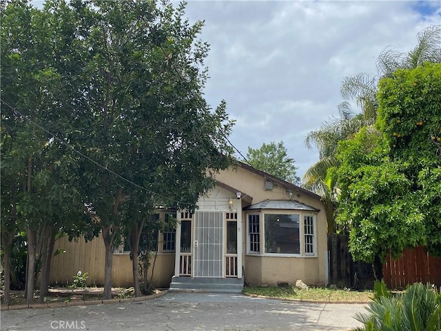 view of front of house featuring fence and stucco siding