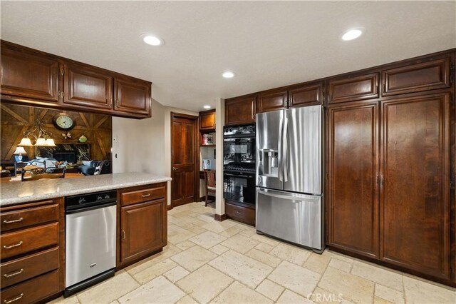kitchen featuring dobule oven black, light countertops, stainless steel fridge, recessed lighting, and stone tile floors