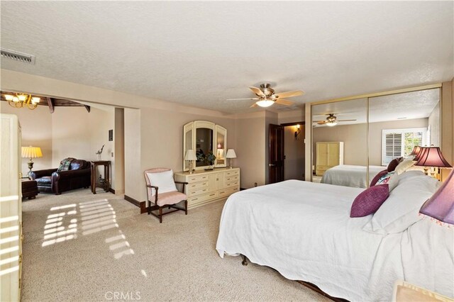 carpeted bedroom with visible vents, a textured ceiling, ceiling fan, and baseboards