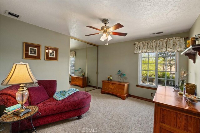 interior space featuring visible vents, carpet flooring, baseboards, and ceiling fan