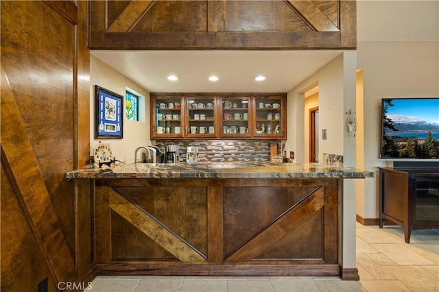 bar with baseboards, decorative backsplash, recessed lighting, and stone tile floors