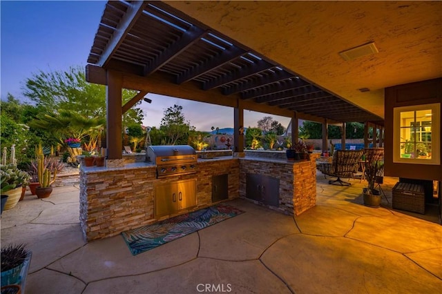 view of patio / terrace featuring exterior kitchen and a grill