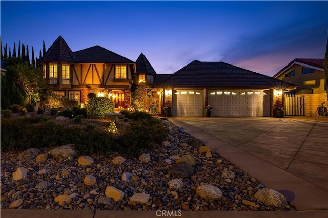 view of front facade with an attached garage, driveway, and a gate