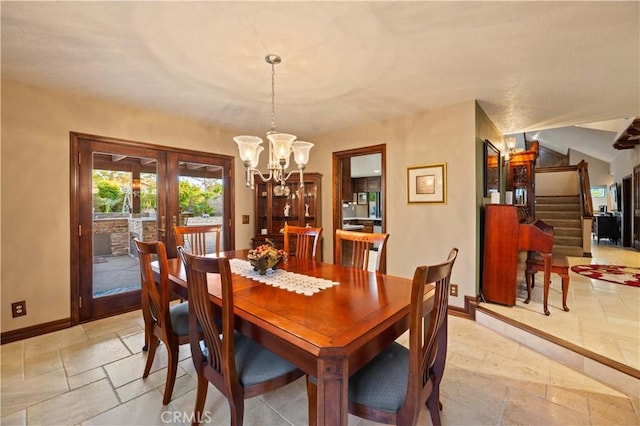 dining area featuring a notable chandelier, french doors, baseboards, stairway, and stone tile flooring