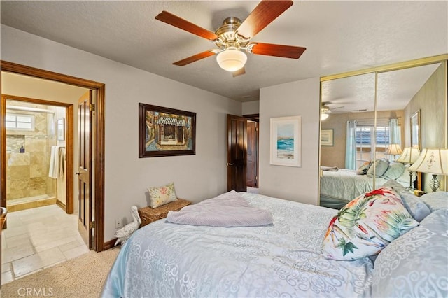 bedroom with a closet, baseboards, ceiling fan, light colored carpet, and a textured ceiling