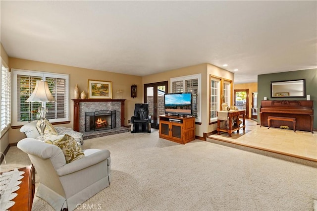 carpeted living room with baseboards, a warm lit fireplace, and a wealth of natural light