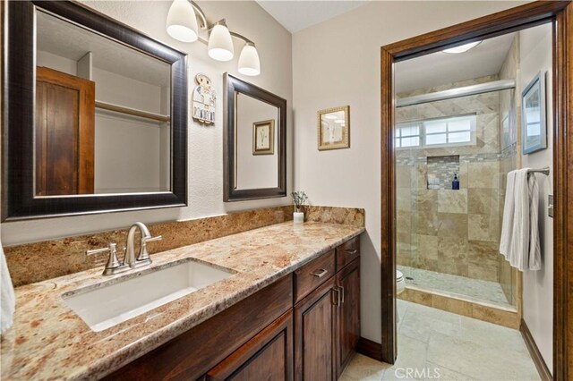 bathroom with vanity, toilet, baseboards, tile patterned floors, and a shower stall
